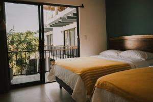 a bedroom with two beds and a balcony at House with private pool, walking distance to beaches & restaurants in Puerto Escondido +26 photos
