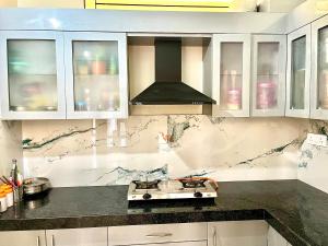 a kitchen with white cabinets and a stove at Your second home in Jaipur