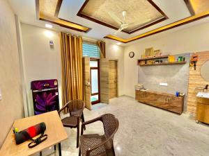 a living room with a table and chairs and a tv at Your second home in Jaipur