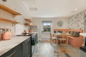 eine Küche mit Tisch und Arbeitsplatte in der Unterkunft Mill Cottage - North East Escapes in Belford