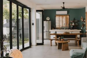 a kitchen and living room with green walls and a table at House with private pool, walking distance to beaches & restaurants in Puerto Escondido