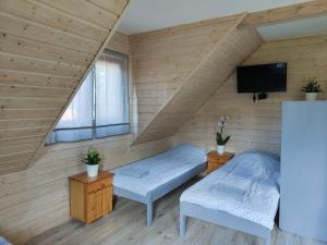 a room with two beds and a flat screen tv at ekoLOKUM - kameralnie, blisko centrum in Ostróda