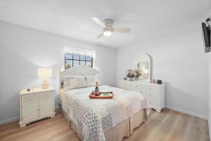 a bedroom with a bed and two dressers and a mirror at Cozy townhouse centrally located on the island in Marco Island +23 photos