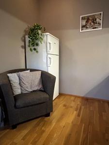a living room with a chair and a refrigerator at Studioleilighet i Tromsø in Tromsø