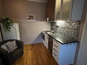 a small kitchen with a sink and a chair at Studioleilighet i Tromsø in Tromsø
