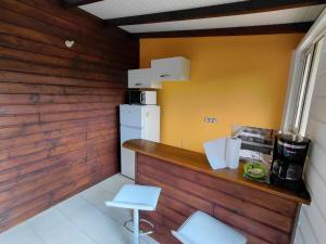 a kitchen with a counter and a white refrigerator at Bungalow Dumonter in Baie-Mahault