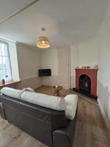 a living room with a couch and a fireplace at Petite maison avec jardin à Bagnoles de l'Orne in Bagnoles de l'Orne