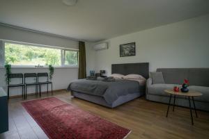 a bedroom with a bed and a couch at OZ - Obecana Zemlja Permaculture Homestead in Blagaj