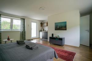 a bedroom with a bed and a table and windows at OZ - Obecana Zemlja Permaculture Homestead in Blagaj