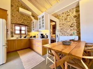 a kitchen with a wooden table and a refrigerator at The Stone House - Two Bedrooms Maisonette in Avdhoulianá