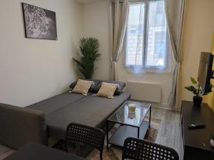 a living room with a couch and a table at Appartement RDC Soleil in La Flèche