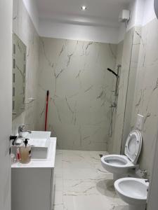 a white bathroom with a toilet and a sink at Eldi's Home in Vlorë +27 photos
