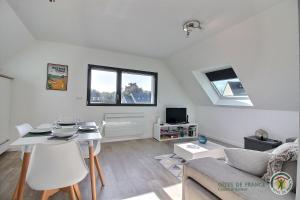 ein Wohnzimmer mit einem Tisch und einem Sofa in der Unterkunft Les agapanthes in Perros-Guirec