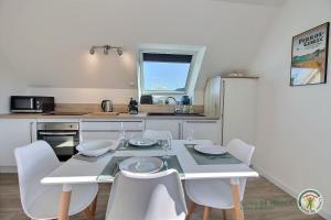 eine Küche mit einem Tisch und Stühlen in einer Küche in der Unterkunft Les agapanthes in Perros-Guirec