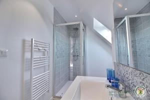 ein weißes Badezimmer mit Dusche und Waschbecken in der Unterkunft Les agapanthes in Perros-Guirec + 11 Fotos