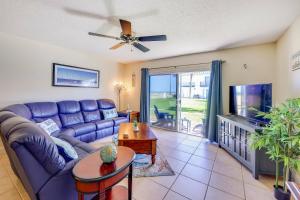オーモンド・ビーチにあるOceanfront Ormond Beach Condo Patio, Pool Access!の青いソファとテレビのあるリビングルーム