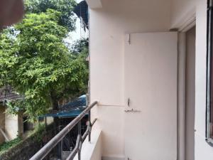 a balcony of a building with trees in the background at Bhavishya Home in Nashik