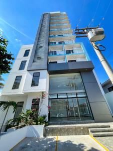 a tall white building with windows and a street light at Two-bedroom apartment in Santa Cruz de la Sierra