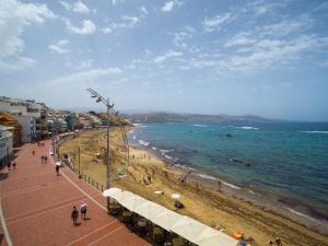 una spiaggia con persone che camminano sulla sabbia e sull'oceano di Apartamento Primera línea playa a Las Palmas de Gran Canaria