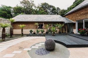 a house with a courtyard with a garden at Shizuka Lodge - Award-Winning Gardens near Ventnor in Ventnor