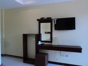 a room with a mirror and a tv on a wall at Greenfields Tourist Inn in Panglao