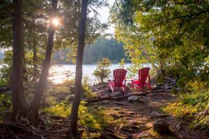 twee rode stoelen aan de oever van een meer bij Cachet Crossing in Blue Mountains +8 foto's