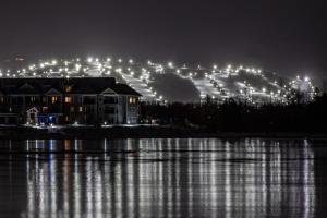 a building at night with lights on a lake at Cachet Crossing by Property Valet in Blue Mountains