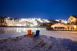 two chairs and a table in the snow at night at Cachet Crossing by Property Valet in Blue Mountains +81 photos