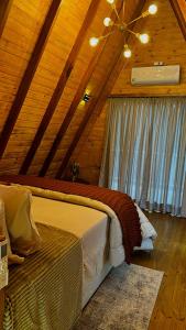 a bedroom with a bed in a wooden cabin at Chalé Sossego da Mata in São José dos Pinhais