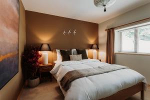 a bedroom with a large bed and a window at Shizuka Lodge - Award-Winning Gardens near Ventnor in Ventnor