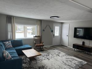 a living room with a blue couch and a tv at Charming 3-bedroom house in Traverse City
