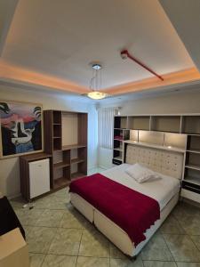 a bedroom with a large bed and some shelves at Residencial Refugio do Mar in Florianópolis