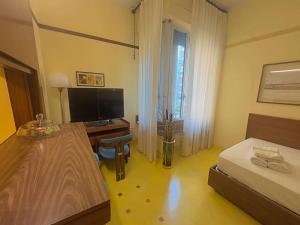 a bedroom with a desk and a bed and a television at Appartme Nuova 52 in Milan