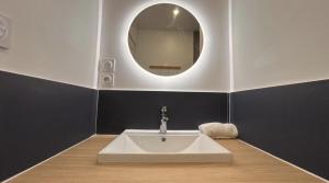 a bathroom with a white sink and a mirror at Le Singulier Calme Central Chic in Le Creusot +5 photos