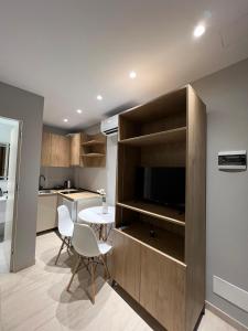 a kitchen and living room with a tv and a table at Vila Serenita in Vlorë