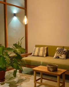 a living room with a green couch and a table at Gaia - Casa de Playa in Canoas de Punta Sal +19 photos