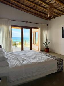 a bedroom with a bed and a view of the ocean at Gaia - Casa de Playa in Canoas de Punta Sal