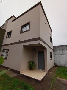 a white house with a door and a potted plant at Duplex Los Araujos in Yerba Buena