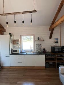 a kitchen with white cabinets and a sink and a window at Gîte au cœur des Landes in Lue +12 photos