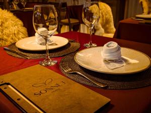 a table with plates and wine glasses and a napkin at Hotel Sonnet Curitiba in Curitiba