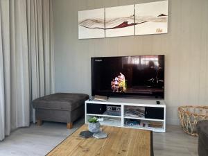 a living room with a flat screen tv at Luxe Duinsuite in Groet