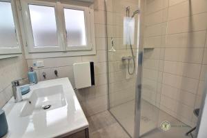 a bathroom with a shower and a white sink at La venelle in Saint-Quay-Portrieux +38 photos