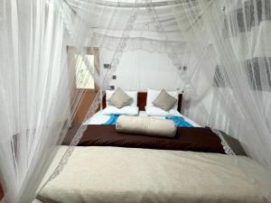 a bedroom with a canopy bed with white curtains at Ella Serene Stay in Ella