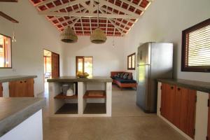 a kitchen with a refrigerator and a table at Villa Estrelas Atins in Atins +26 photos