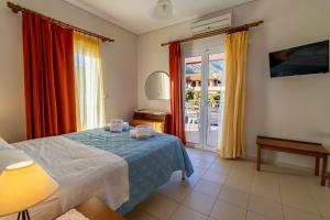 a bedroom with a bed and a sliding glass door at Apartments Thekla in Karavádhos