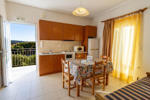 a kitchen with a table and chairs and a kitchen with a window at Apartments Thekla in Karavádhos