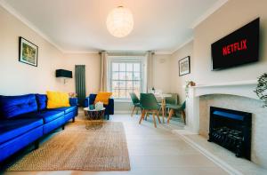 a living room with a blue couch and a fireplace at London's Great Escape 2 Bed Flat in London