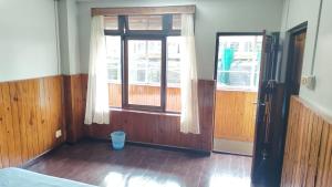 an empty room with a window and a door at Sayana Homestay in Darjeeling +9 photos