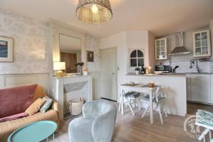a living room with a couch and a kitchen at La terrasse du champ clos in Dinan +20 photos