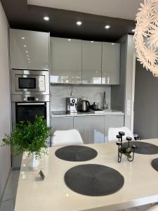 une cuisine avec des appareils en acier inoxydable et des armoires blanches dans l'établissement Gemütliche Ferienwohnung 479 im Panoramic Hohegeiß Braunlage mit Pool und Sauna, à Braunlage